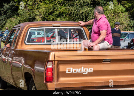 Man with beer glass riding in back of a Dodge pickup truck, at a classic car show, Hinton Arms, Cheriton, Hampshire, UK Stock Photo