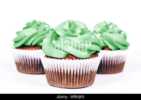 Three delicious cupcakes with icing in trendy neo mint color on white background. Close-up. Stock Photo
