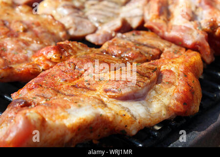 Pork neck getting grilled on open fire Stock Photo