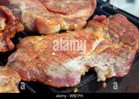 Pork neck getting grilled on open fire Stock Photo