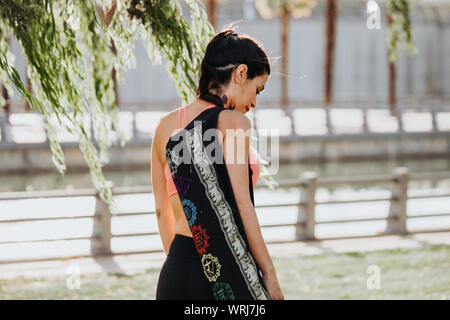 Latin Woman Prepares for Yoga Session with Shoulder Mat. Stock Photo