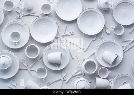 Many dishes and appliances are painted white on white surface, the concept of excessive consumption, selective focus Stock Photo