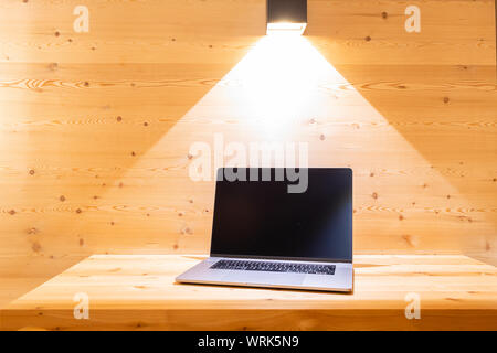 Laptop placed on wooden wall work desk in hotel room Stock Photo
