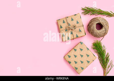 Christmas gift box and sprigs of Christmas tree on pink background. Hand made Stock Photo