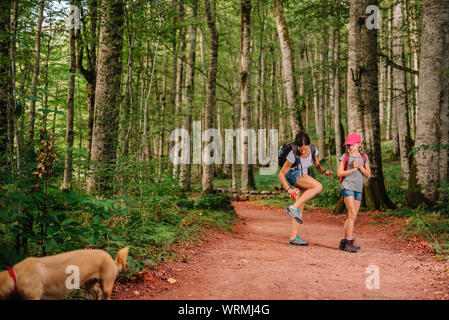 Mother and her daughter hiking in the forest and she applying mosquito repellent on the skin Stock Photo