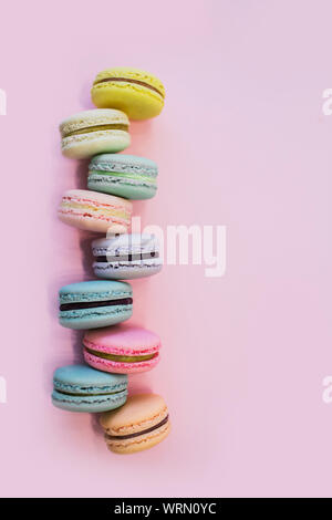 Macaron or macaroon biscuits on pastel pink background. Almond cookies of pastel colors. Top view. Copy space. Stock Photo
