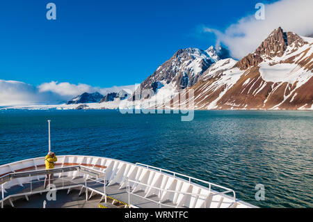 HORNSUND, SVALBARD, NORWAY – JULY 26, 2010:  Photographer on the bow of the National Geographic Explorer cruise ship in the Arctic. Stock Photo