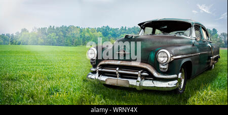 Abandoned vintage car in open field Stock Photo