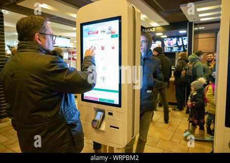 MOSCOW, RUSSIA - CIRCA OCTOBER, 2018: people use self-ordering kiosks at McDonald's restaurant. Stock Photo