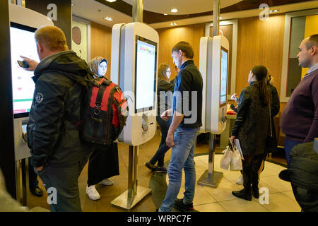 MOSCOW, RUSSIA - CIRCA OCTOBER, 2018: people use self-ordering kiosks at McDonald's restaurant. Stock Photo