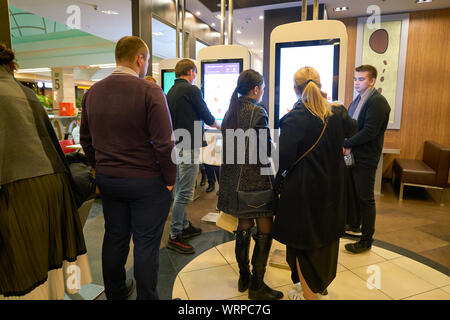 MOSCOW, RUSSIA - CIRCA OCTOBER, 2018: people use self-ordering kiosks at McDonald's restaurant. Stock Photo