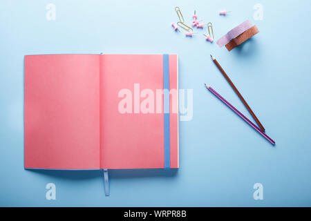 Minimal work space : pink sketchbook and pencils on blue background. Top view , flat lay. Stock Photo