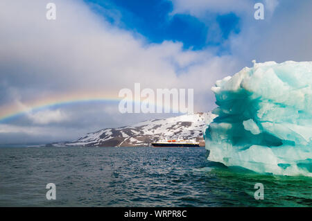 HORNSUND, SVALBARD, NORWAY – JULY 26, 2010:  National Geographic Explorer cruise ship in front of a glacier in the Arctic Ocean. Stock Photo