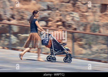 Cordoba, Spain - June 20, 2019: Mother pushing a baby carriage Stock Photo