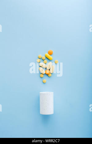 Pharmaceutical medicine pills and bottle on blue background. Stock Photo