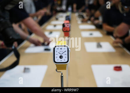 Cupertino, USA. 10th Sep, 2019. Journalists at a product presentation in the Steve Jobs Theater on the company campus are standing at a table showing the new Apple Watches. Apple also presented three new iPhone models and a new entry-level iPad at the event. The Series 5 of the Apple Watch has a new OLED display, which can stay 'always on' instead of being switched off automatically after a short time. Credit: Christoph Dernbach/dpa/Alamy Live News Stock Photo
