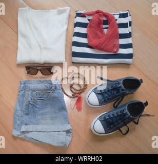 Women summer clothes collection on wood background. Top view. Stock Photo