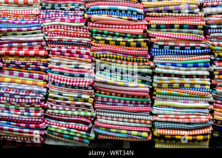 Stacks of colorful fabric scarves are for sale at the main Central Market in Phnom Penh, Cambodia. Stock Photo