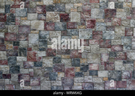 Beautiful textured marble looking tile wall background with colorful blocks in shades of rosy red, beige, and gray blue Stock Photo