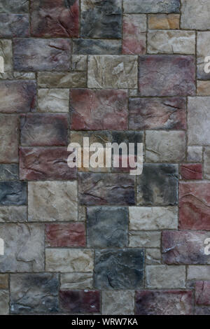 Beautiful textured marble looking tile wall background with colorful blocks in shades of rosy red, beige, and gray blue Stock Photo