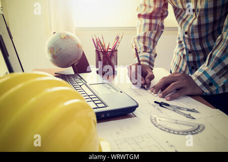 Architect drawing construction plan with laptop in office Stock Photo