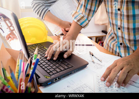Two colleagues discussing data working with construction plan in office. Stock Photo