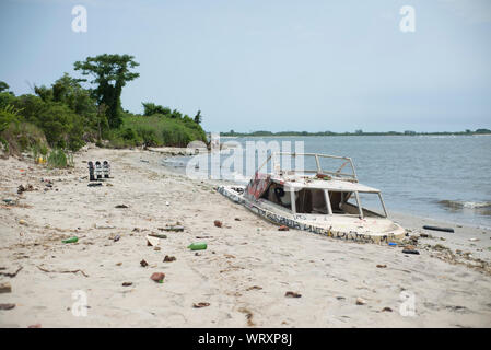 A derelict boat buried in the sand at Dead Horse Bay in Brooklyn, New York. The boat was deposited there by Hurricane Sandy. Stock Photo