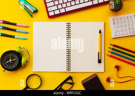 Blank white notepad with office and personal accessories isolated on yellow background, Business motivation and inspiration concepts. Stock Photo