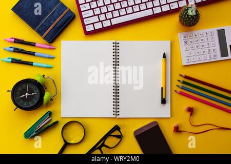 Blank white notepad with office and personal accessories isolated on yellow background, Business motivation and inspiration concepts. Stock Photo