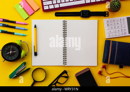 Blank white notepad with office and personal accessories isolated on yellow background, Business motivation and inspiration concepts. Stock Photo