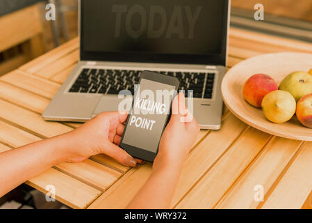 Conceptual hand writing showing Killing Point. Concept meaning Phase End Review Stage Gate Project Evaluation No Go woman with laptop smartphone and o Stock Photo