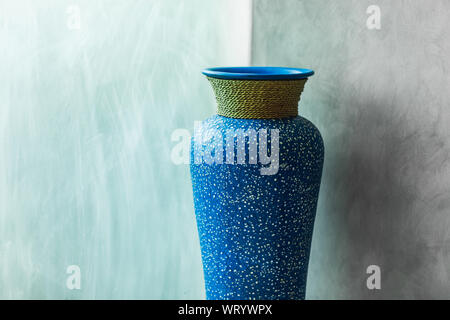 Blue vintage vase on gray concrete wall background. Minimalist modern interior design Stock Photo