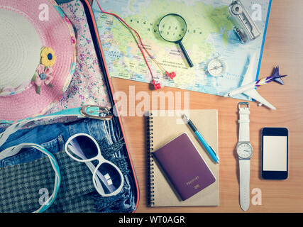 Set of travel accessory in the luggage with smart phone and personal items on wooden background Stock Photo