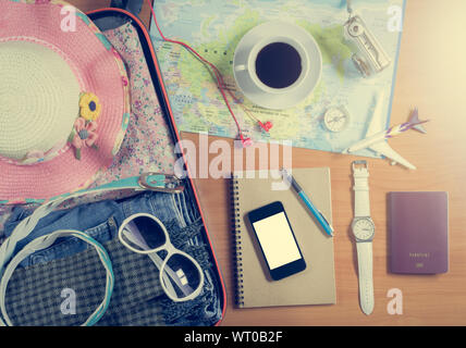 Set of travel accessory in the luggage with smart phone, coffee and personal items on wooden background Stock Photo