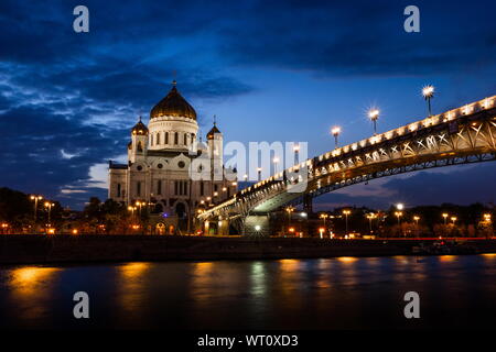 Illuminated Cathedral of Christ the Savior framed with old style street lights of Patriarchy Bridge at night. Stock Photo