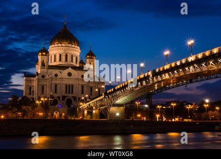 Illuminated Cathedral of Christ the Savior framed with old style street lights of Patriarchy Bridge at night. Stock Photo