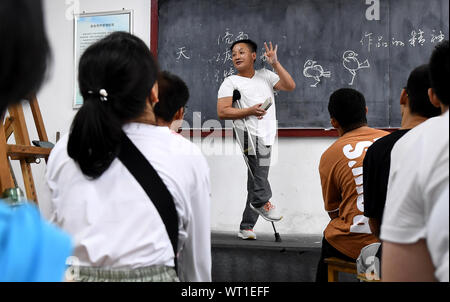 Beijing, China's Shaanxi Province. 9th Sep, 2019. Wang Xuyang, an art teacher, teaches painting knowledge to students majored in computer graphic design at Shaanxi Urban Economy School, a special vocational school for students with disabilities, in Xi'an, northwest China's Shaanxi Province, Sept. 9, 2019. Wang contracted polio as a child, and could only walk with the help of a crutch. Credit: Liu Xiao/Xinhua/Alamy Live News Stock Photo
