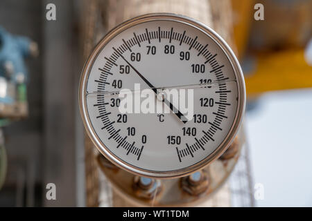 Analog temperature gauge for reading discharge temp of compressor at offshore oil and gas wellhead remote platform. Stock Photo