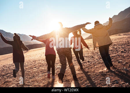 Happy friends having fun and runs at sunset. Togetherness or freedom concept Stock Photo