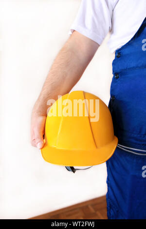 Construction worker and handyman is working on renovation of apartment. Builder at construction site with protective uniform and equipment. Stock Photo