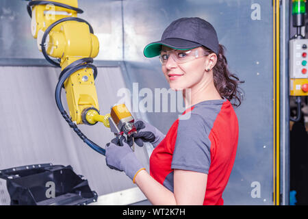 A young female technician while machine constructing in a manufacturing plant Stock Photo