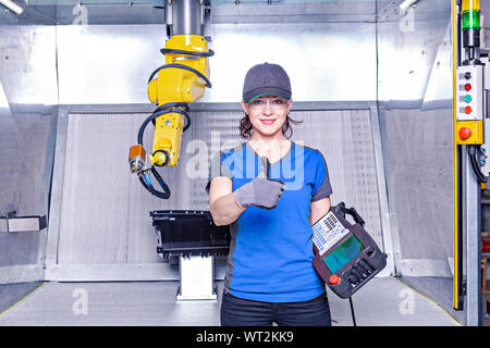 A young female technician while machine constructing in a manufacturing plant Stock Photo