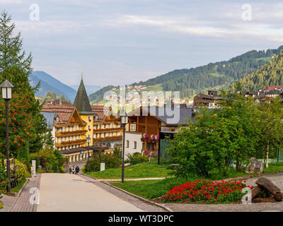 SELVA VAL DI GARDENA, ITALY - SEPTEMBER 1, 2019: View of the town, early morning. With pedestrians. Colourful, floral town in the Dolomite mountains. Stock Photo