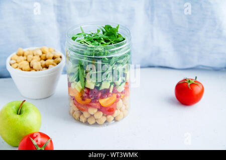 Healthy salad with chickpeas and arugula in a jar. Take away easy lunch concept Stock Photo