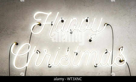 Neon sign that says the word Happy Christmas in bright white on a grunge concrete wall background, Christmas decoration sign Stock Photo