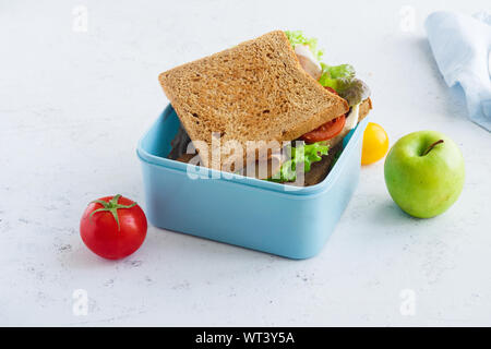 Healthy sandwich with greens, ham, tomatoes and cheese packed in plastic container. Takeaway food for lunch at school or at work. Stock Photo