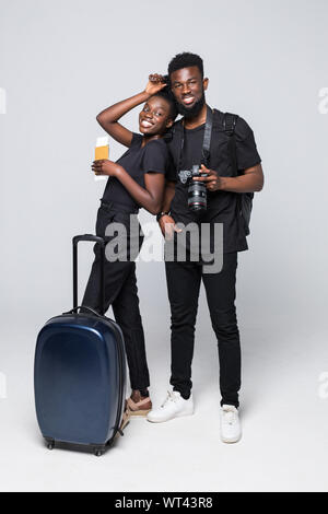 Full length portrait of young african couple walking with suitcases for travel isolated over white background Stock Photo