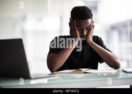 African man sleeping at his workplace in office Stock Photo