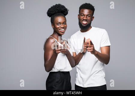 Cheerful african couple pointing fingers at camera, isolated on white background Stock Photo