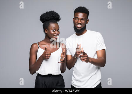 Cheerful african couple pointing fingers at camera, isolated on white background Stock Photo